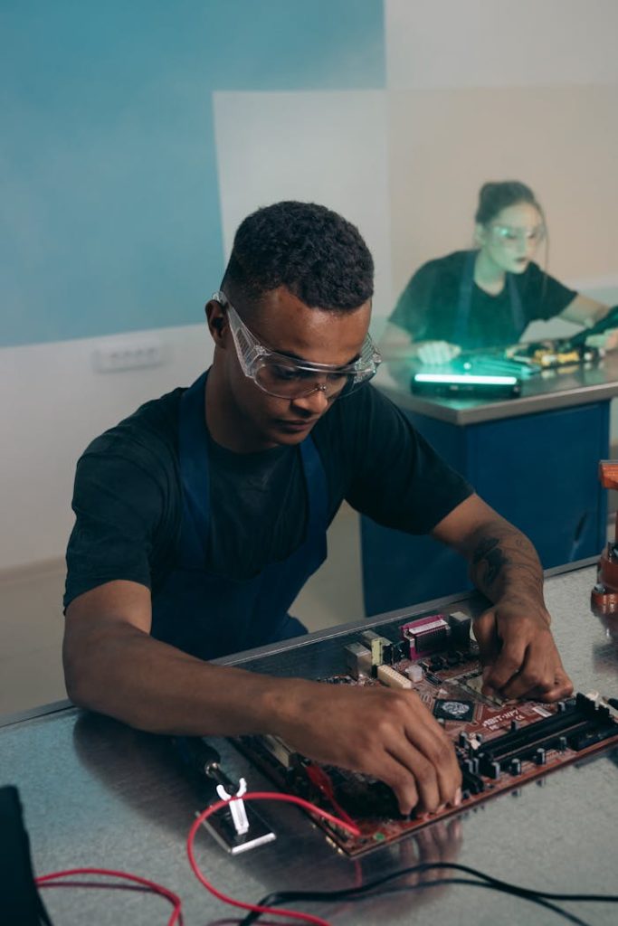 Engineer assembling and testing electronic hardware in a lab environment.
